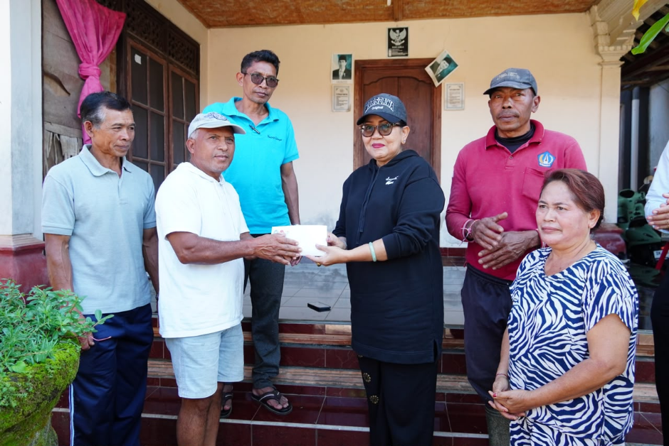 SERAHKAN BANTUAN: Ketua TP PKK Provinsi Bali, Ny. Putri Koster, menyerahkan bantuan usai meninjau telajakan di sepanjang jalan menuju Pura Kahyangan Jagat Kancing Gumi, Desa Adat Batu Lantang, Desa Sulangai, Kecamatan Petang, Kabupaten Badung, Minggu (7/6) pagi. (Foto: Hms Pemprov Bali)