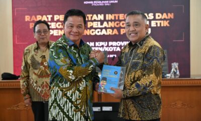 Ketua DKPP RI Heddy Lugito menyerahkan buku kepada Ketua KPU Bali Lidartawan dalam rapat penguatan integritas penyelenggara Pemilu