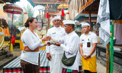 Ketua WHDI Badung Nyonya Yunita Alit Sucipta menyerahkan punia saat menghadiri Upacara Melaspas Tapakan Ida Batara di Pura Dalem Merta Ening Manik Galih, Bongkasa, Kamis (30/7).