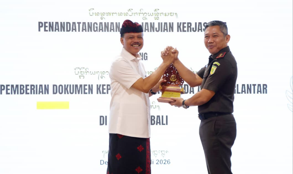 Sekda Bali Dewa Indra menerima cinderamata saat menghadiri penandatanganan PKS pemberian dokumen kependudukan anak telantar di Kejaksaan Tinggi Bali, Kamis (30/7).