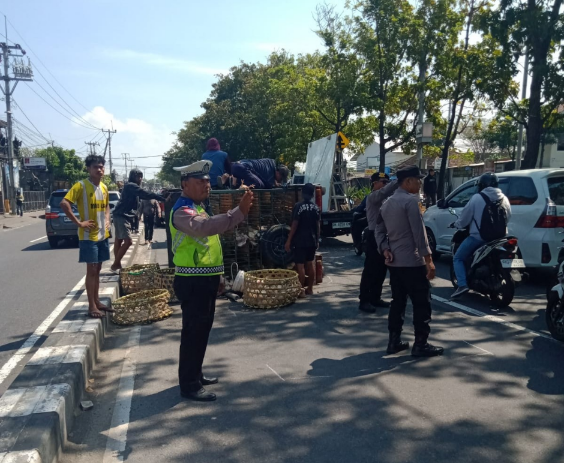 Personel Polsek Denpasar Timur melakukan pengamanan lokasi kecelakaan beruntun tiga kendaraan di Jalan By Pass IB Mantra, Minggu (2/8/2026).