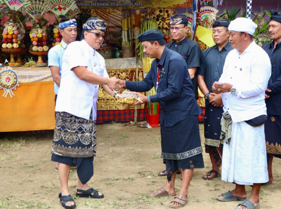 Wakil Gubernur Bali I Nyoman Giri Prasta menyerahkan punia saat menghadiri upacara Ngaben Massal di Desa Adat Mengandang, Kecamatan Kubutambahan.