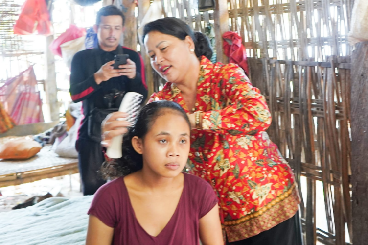 Ketua BKOW Bali Seniasih Giri Prasta menyisir rambut warga penyandang gangguan mental di Desa Seraya Timur, Karangasem