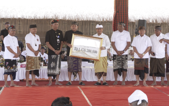 Bupati Badung I Wayan Adi Arnawa menyerahkan dana hibah saat menghadiri Karya Agung Pitra Yadnya Ngaben Massal Desa Adat Jimbaran, Selasa (1/9).