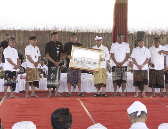 Bupati Badung I Wayan Adi Arnawa menyerahkan dana hibah saat menghadiri Karya Agung Pitra Yadnya Ngaben Massal Desa Adat Jimbaran, Selasa (1/9).