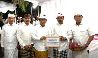 Bupati Badung I Wayan Adi Arnawa menyerahkan bantuan dana hibah saat menghadiri Karya Yadnya Massal Desa Adat Mengwitani, Kecamatan Mengwi, Selasa (1/9).