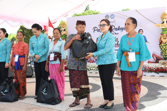 Sekretaris I TP PKK Kota Denpasar Ny. Ayu Kristi Arya Wibawa menyerahkan bingkisan saat menghadiri Pasar Rakyat Berbelanja dan Berbagi di Taman Budaya Kapten A.A. Made Karang Candra Buana, Kabupaten Karangasem, Jumat (4/9/2026).