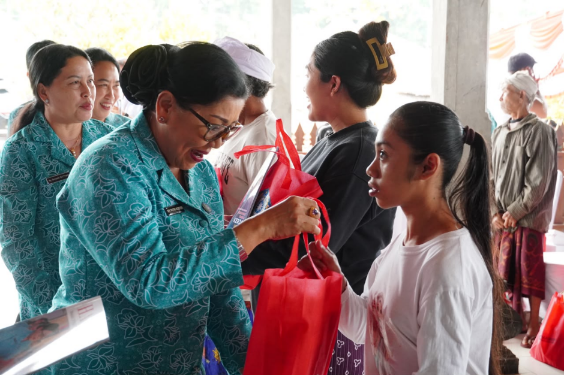 Ketua TP PKK Provinsi Bali Ny. Putri Koster menyerahkan bantuan dalam Aksi Sosial Bergerak dan Berbagi di Desa Pengotan, Bangli.
